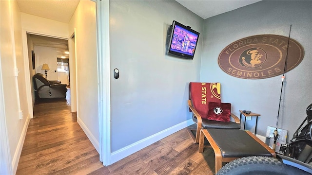 sitting room featuring baseboards and wood finished floors