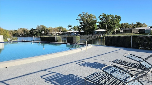 pool with a patio area and fence