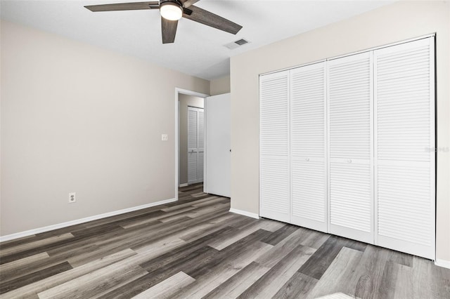 unfurnished bedroom with visible vents, baseboards, wood finished floors, a closet, and a ceiling fan