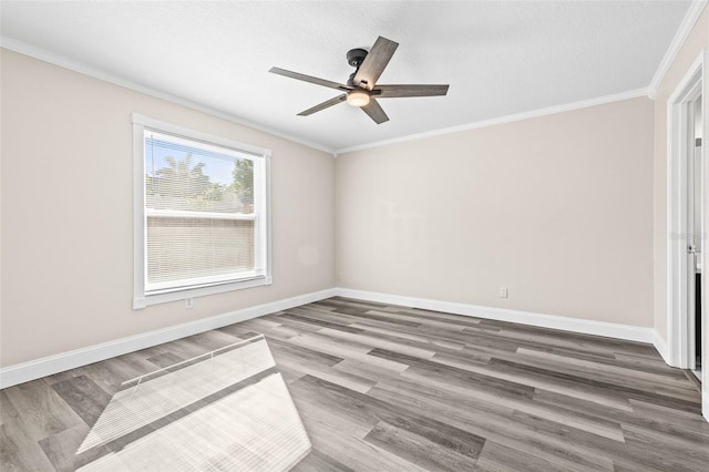 spare room featuring crown molding, wood finished floors, baseboards, and ceiling fan