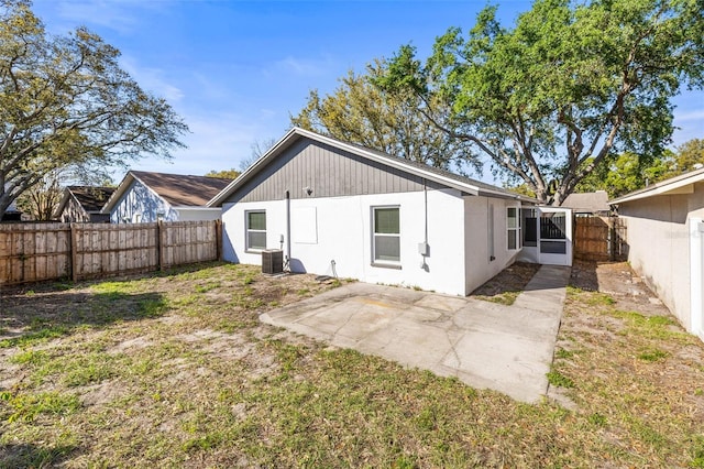 rear view of property with a patio area, central AC unit, and a fenced backyard