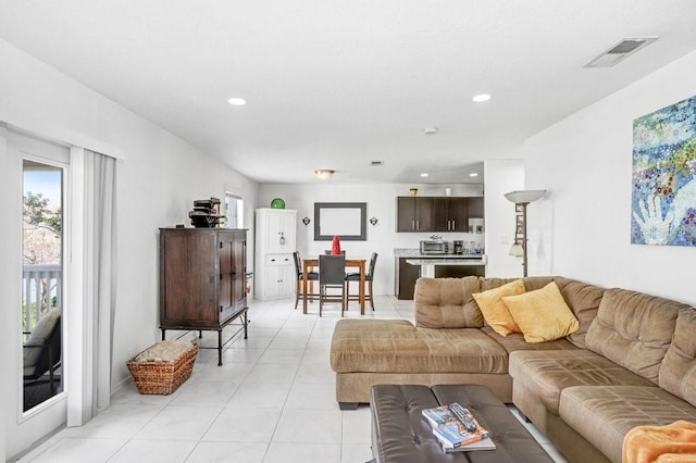 living area featuring light tile patterned flooring, visible vents, and recessed lighting