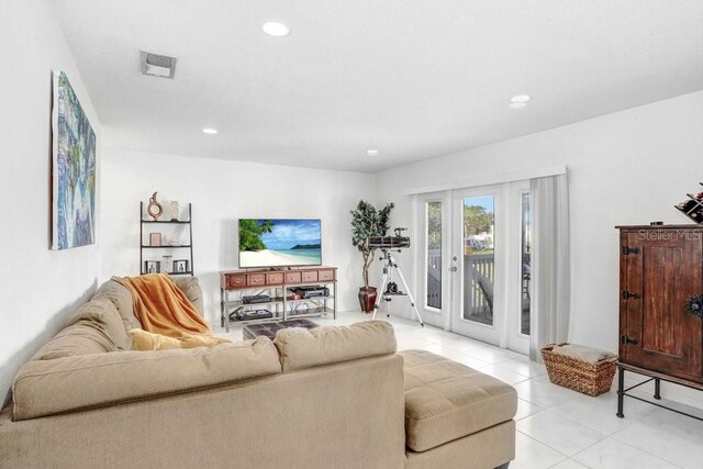 living area with light tile patterned flooring, recessed lighting, visible vents, and french doors