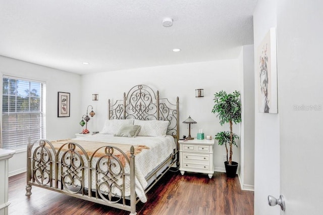 bedroom with recessed lighting, baseboards, and dark wood-style flooring