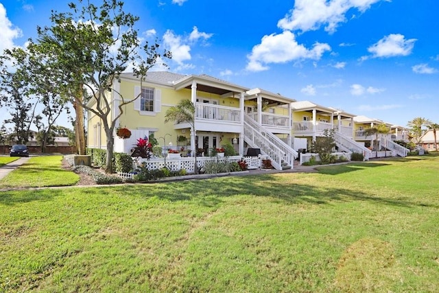 back of property featuring stucco siding, a lawn, and stairs