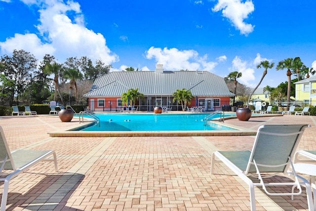 community pool with fence and a patio area