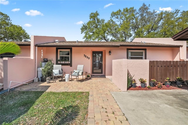 exterior space with stucco siding, a patio, and fence