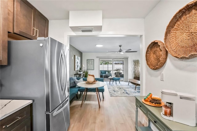 kitchen featuring visible vents, ceiling fan, dark brown cabinetry, freestanding refrigerator, and light wood-style floors