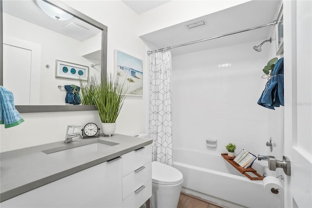 full bath featuring shower / bath combo with shower curtain, toilet, and vanity