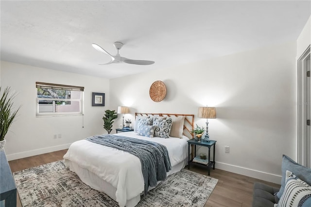 bedroom with ceiling fan, baseboards, and wood finished floors