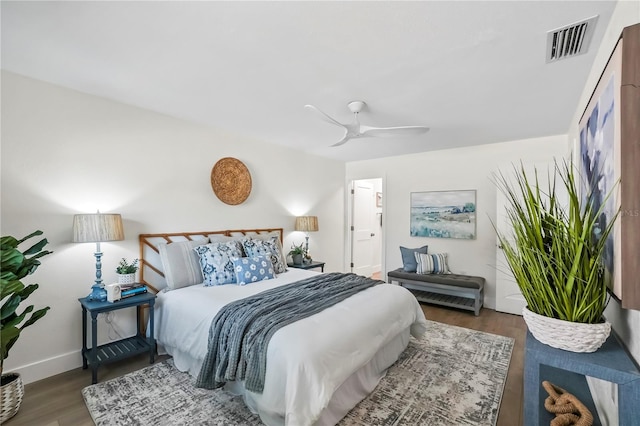 bedroom with visible vents, baseboards, wood finished floors, and a ceiling fan