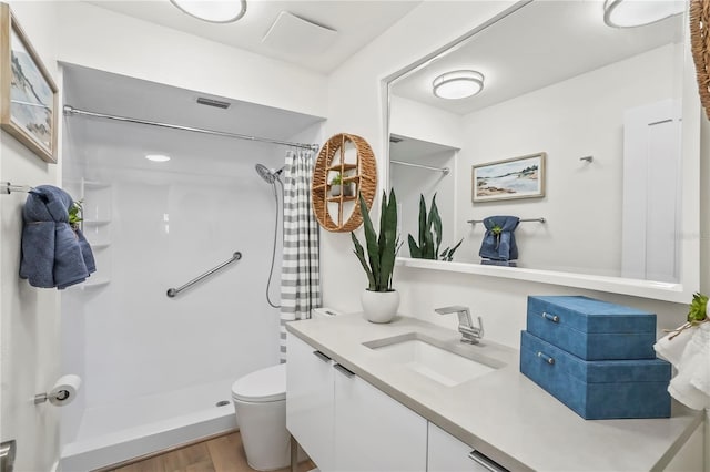 full bathroom featuring vanity, a shower with curtain, wood finished floors, visible vents, and toilet