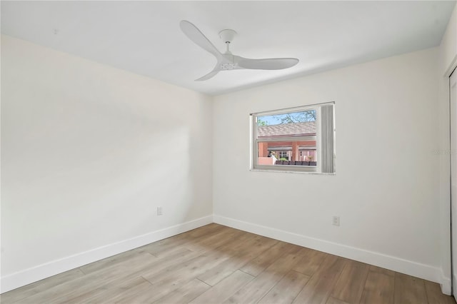 spare room with baseboards, light wood-type flooring, and ceiling fan