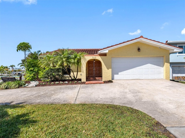 view of front of house with stucco siding, a tiled roof, concrete driveway, and a garage