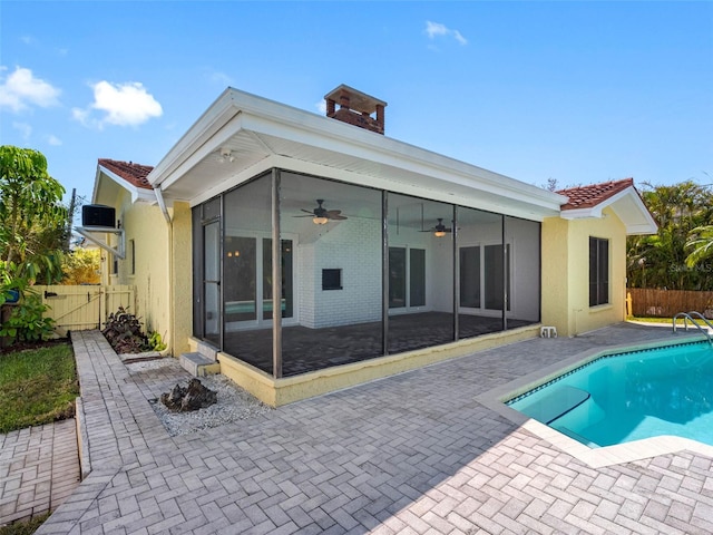 back of property featuring stucco siding, fence, a patio, and a sunroom