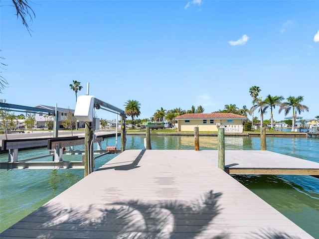 dock area with boat lift and a water view