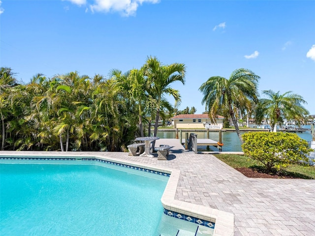 outdoor pool featuring a patio area and a water view