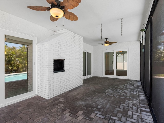 unfurnished sunroom with ceiling fan