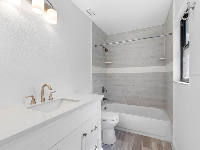 full bath featuring visible vents, toilet, wood tiled floor, bathing tub / shower combination, and vanity