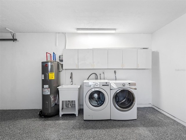 washroom featuring cabinet space, washing machine and dryer, water heater, and a textured ceiling