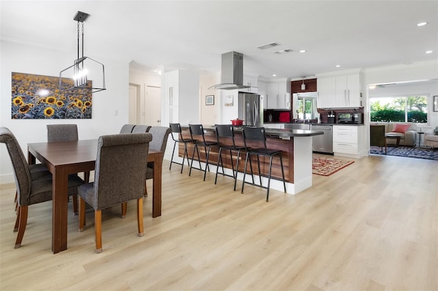 dining space with light wood-style flooring, recessed lighting, visible vents, and a chandelier