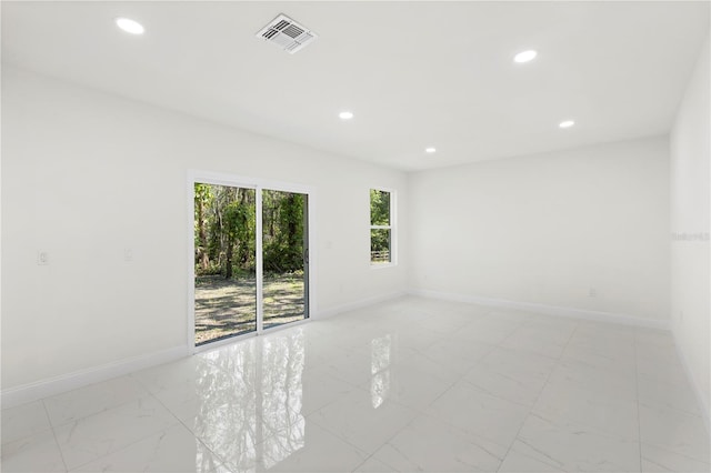unfurnished room featuring baseboards, visible vents, and recessed lighting