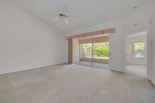 spare room featuring baseboards, high vaulted ceiling, light carpet, and ceiling fan