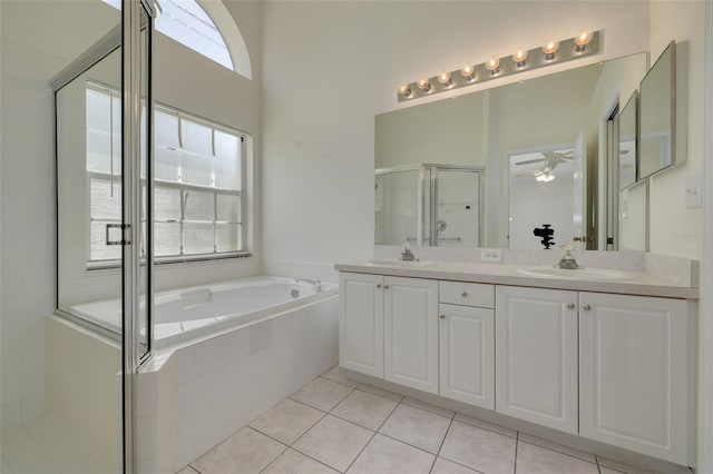 full bath featuring a stall shower, double vanity, a bath, and a sink