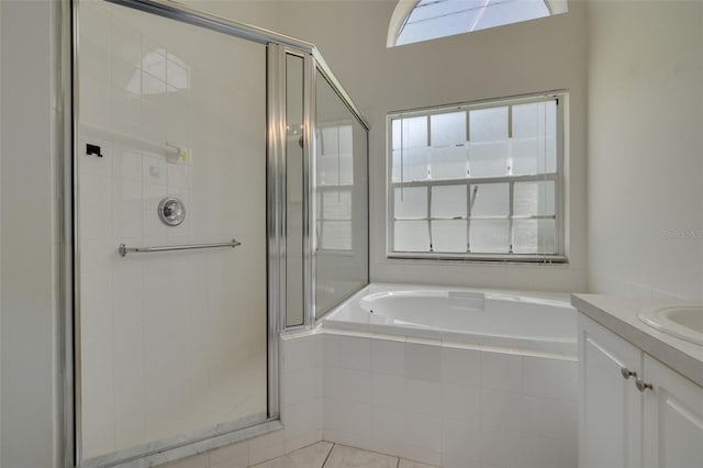 bathroom with a stall shower, a garden tub, tile patterned flooring, and vanity