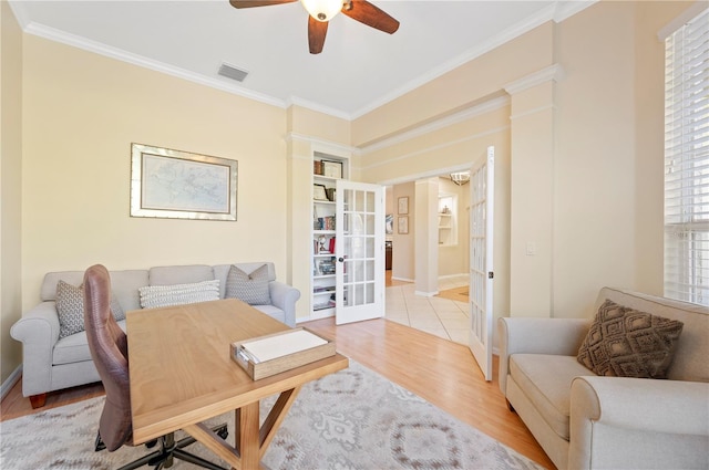 office with baseboards, visible vents, ceiling fan, ornamental molding, and light wood-style floors