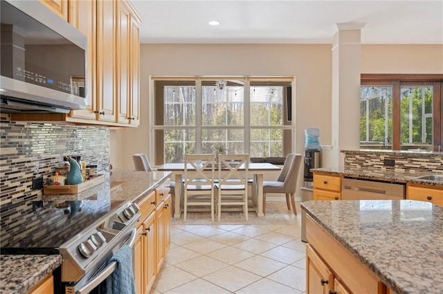 kitchen with backsplash, light stone counters, light tile patterned floors, and stainless steel appliances