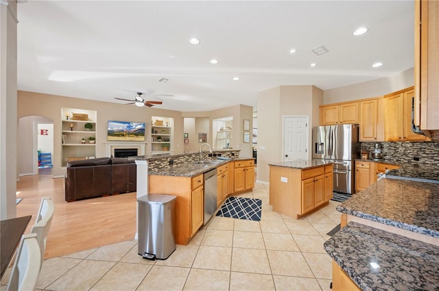 kitchen with visible vents, a kitchen island with sink, a ceiling fan, open floor plan, and appliances with stainless steel finishes