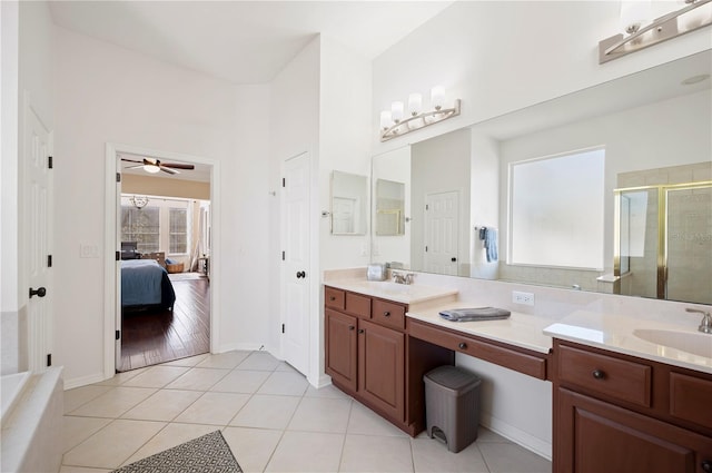 full bath featuring tile patterned flooring, a stall shower, vanity, and ensuite bath