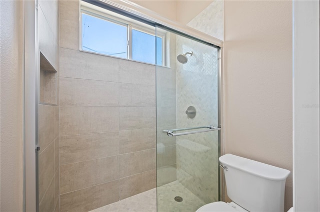 full bath featuring toilet and tiled shower