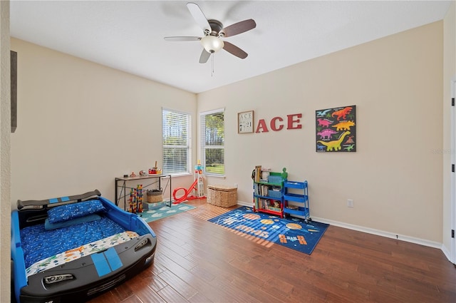 bedroom with a ceiling fan, baseboards, and wood finished floors