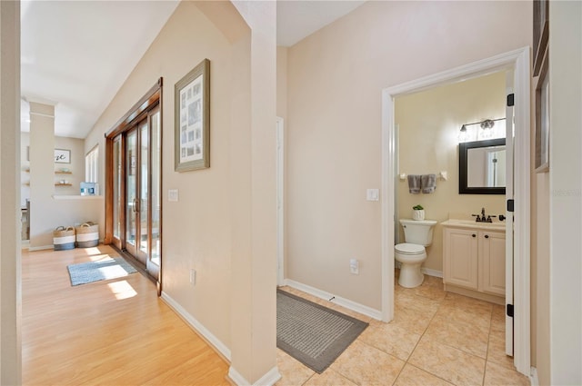 bathroom featuring tile patterned floors, baseboards, toilet, and vanity