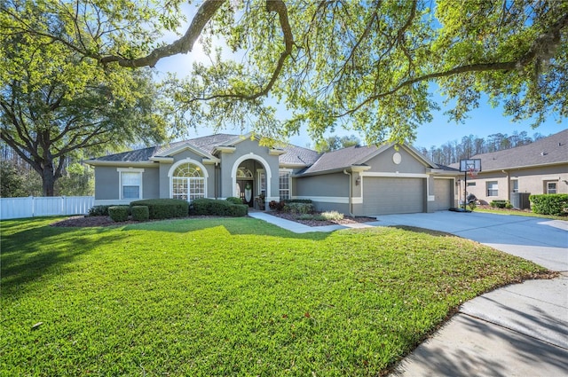 ranch-style home with fence, concrete driveway, a front yard, stucco siding, and a garage