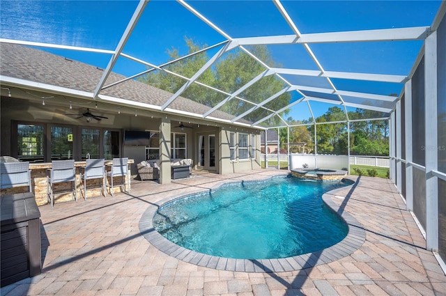 view of pool featuring ceiling fan, a patio, a pool with connected hot tub, and a lanai