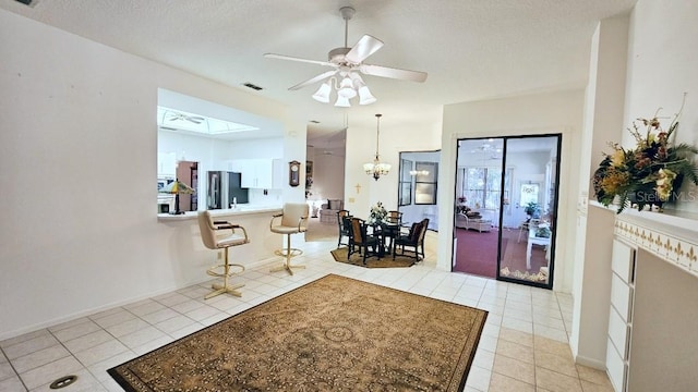 foyer entrance featuring visible vents, ceiling fan with notable chandelier, a textured ceiling, light tile patterned flooring, and baseboards