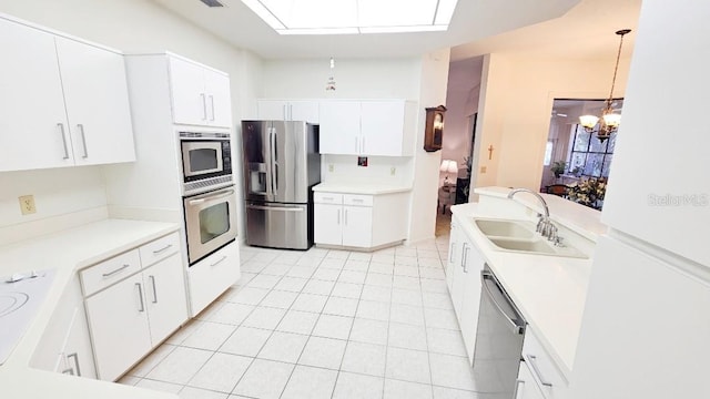kitchen featuring light countertops, white cabinets, appliances with stainless steel finishes, and a sink