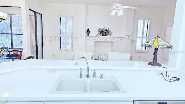 kitchen with dishwasher, light countertops, a ceiling fan, and a sink