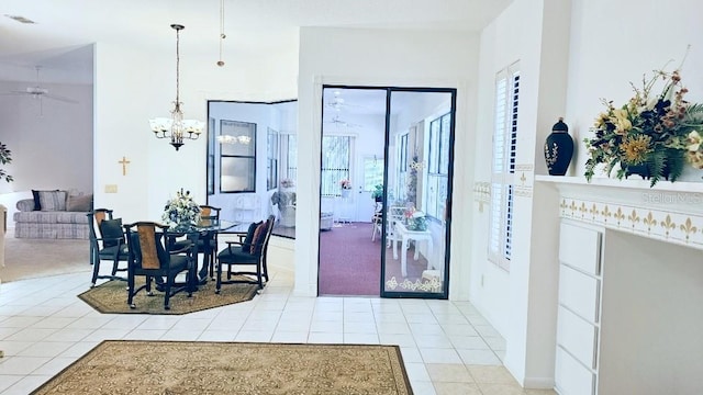 dining room with light tile patterned floors, visible vents, and ceiling fan with notable chandelier
