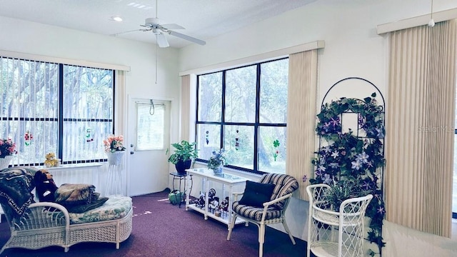 living area featuring carpet flooring and ceiling fan