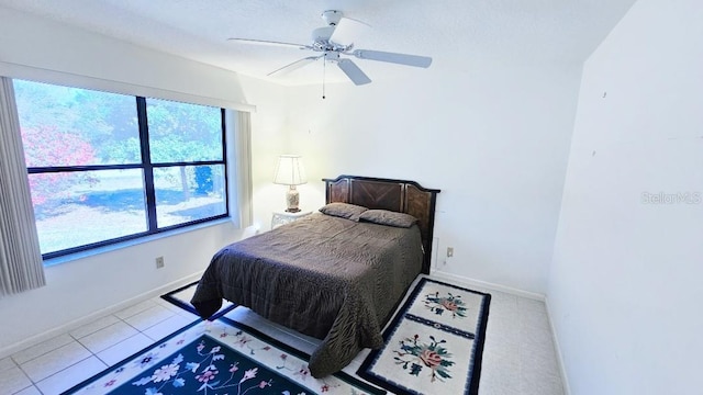 bedroom with tile patterned flooring, baseboards, and ceiling fan