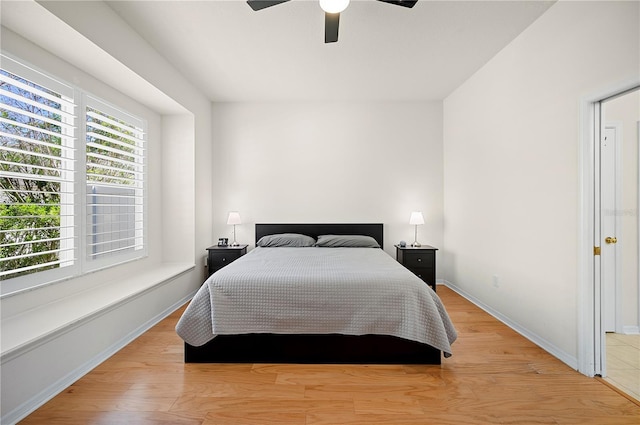 bedroom with a ceiling fan, light wood-style floors, and baseboards