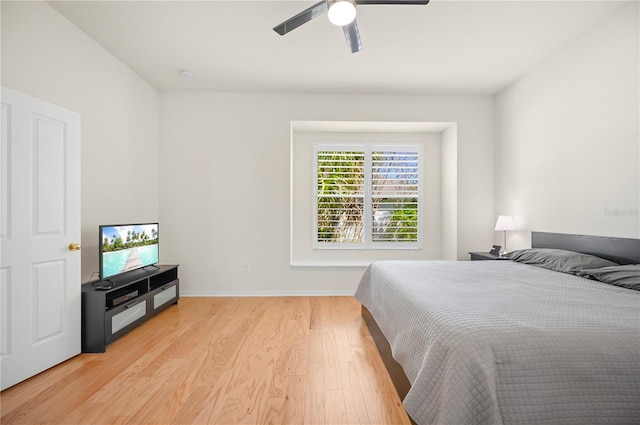 bedroom with ceiling fan, baseboards, and light wood-style floors