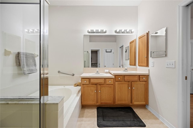 bathroom with a garden tub, a sink, a shower stall, tile patterned flooring, and double vanity