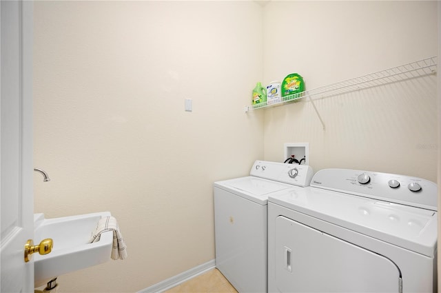 laundry room with washer and clothes dryer, laundry area, baseboards, and light tile patterned floors