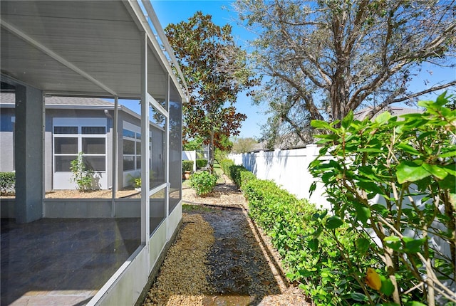 view of yard with a lanai and fence