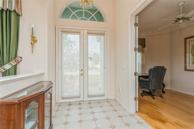 doorway featuring crown molding, baseboards, ceiling fan with notable chandelier, french doors, and wood finished floors